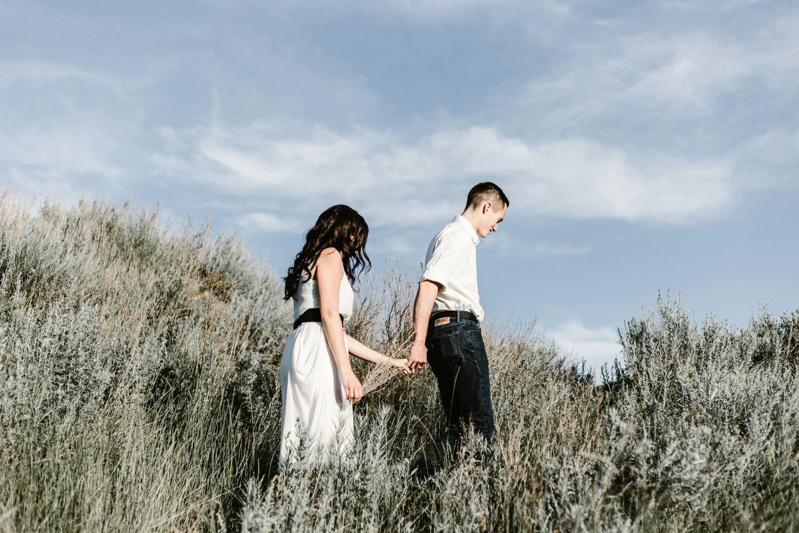 couple walks of grassy field